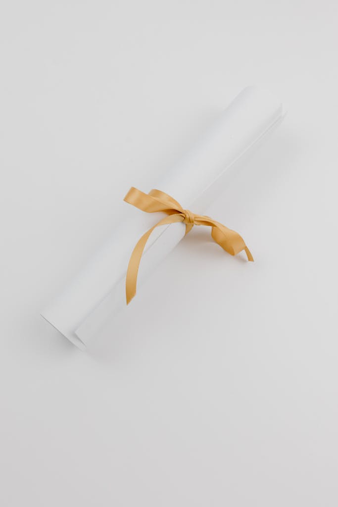 A stylish rolled paper tied with a gold ribbon, symbolizing celebration or achievement.